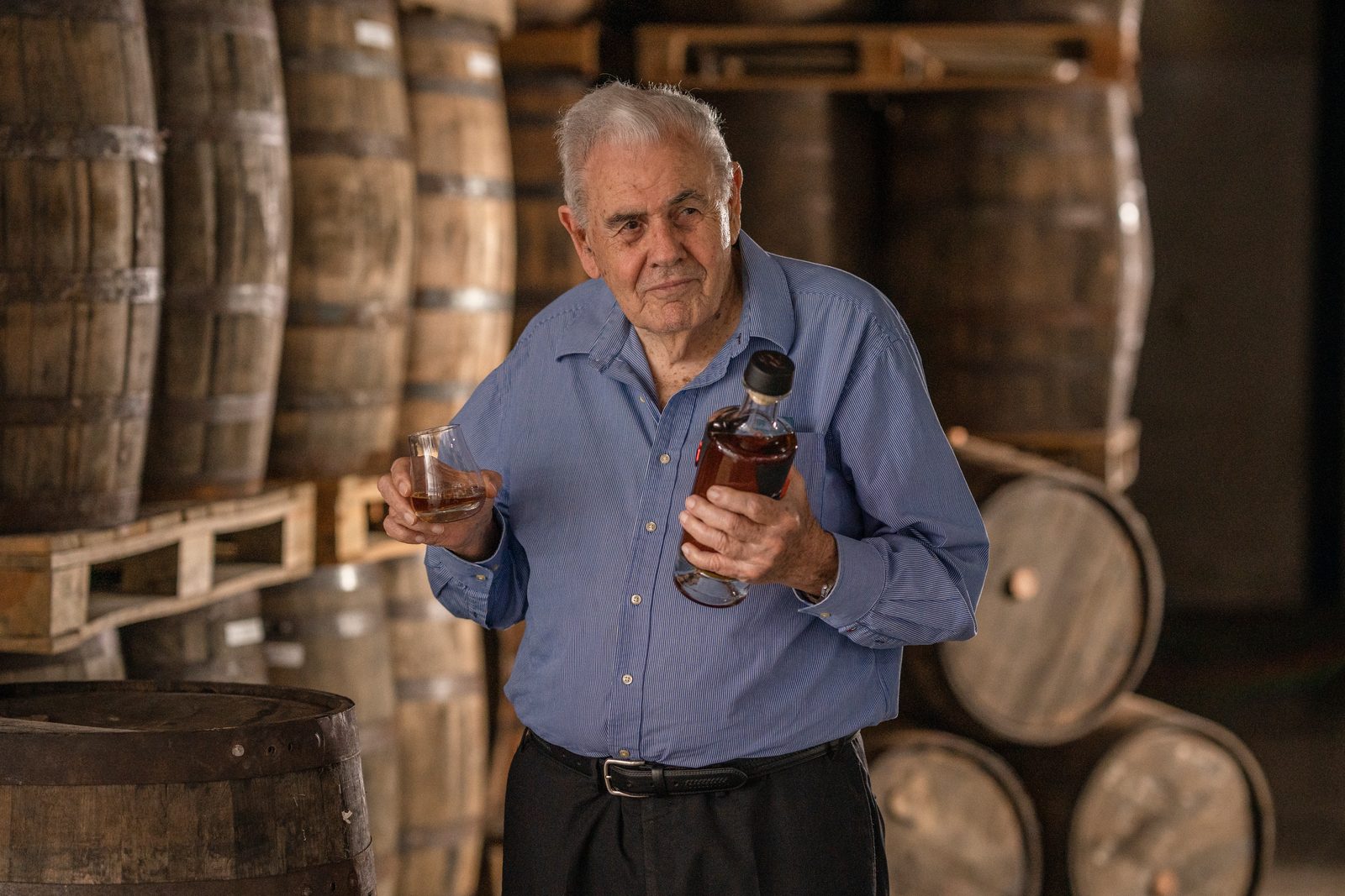 Don Pancho in the warehouse with a bottle and glass